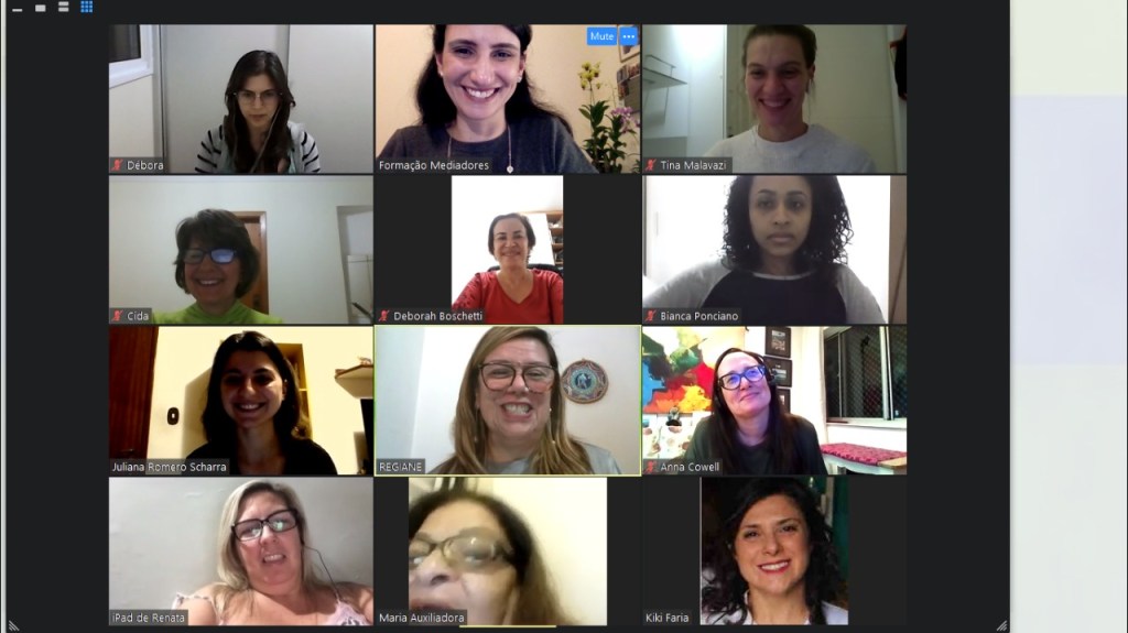 Captura de tela de 12 mulheres reunidas em uma videoconferência. Elas sorriem e posam para foto. Juliana Barica Righini e Regiane Silva estão na reunião. 